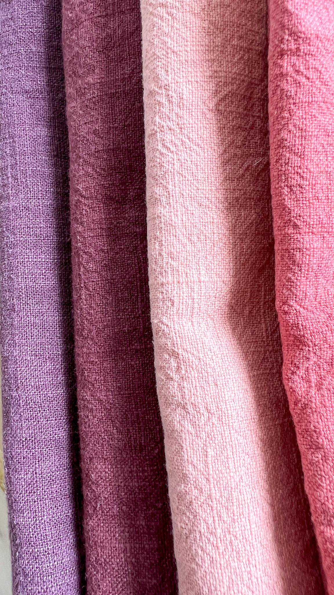 A vibrant array of pink and purple textiles showcasing texture and color.