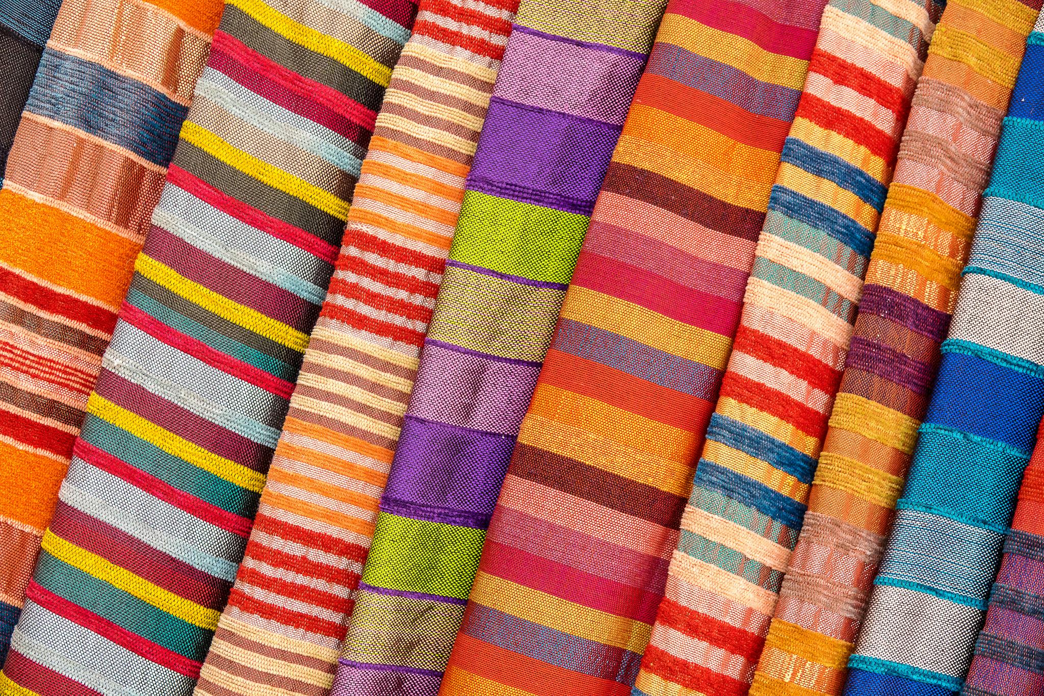 Colorful striped textiles arranged in a vibrant, artistic display, perfect for design inspiration.